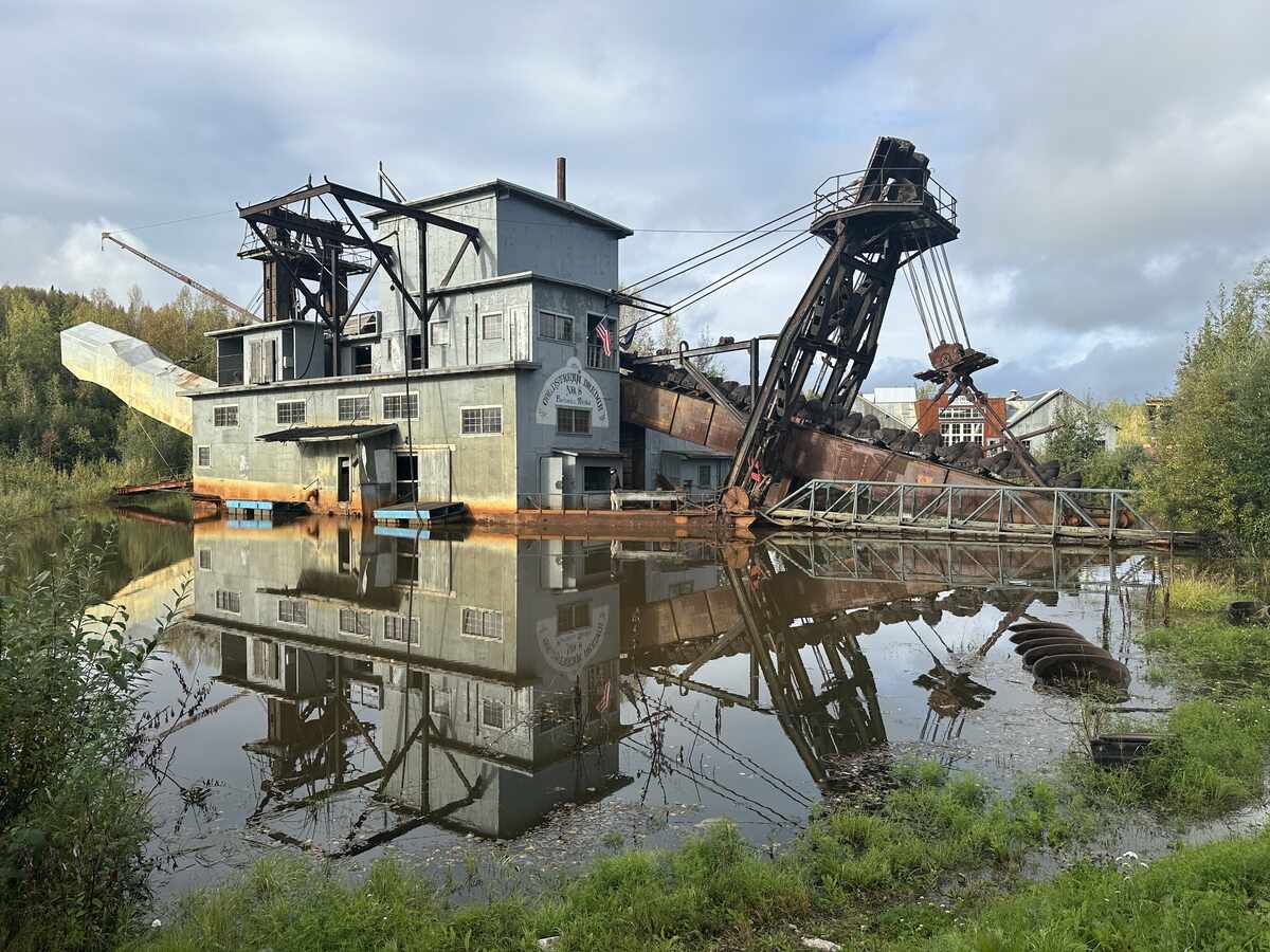 Historic Gold Dredge 8 in Fairbanks, Alaska, reflected in a pond. This massive dredge once mined for gold during the early 20th century gold rush.