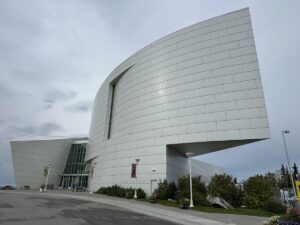 The glacier-inspired white modern building of the University of Alaska’s Museum of the North against a cloudy sky.