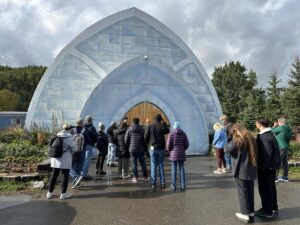 A group of visitors stands outside the arched blue entrance of the Aurora Ice Museum at Chena Hot Springs.