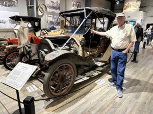 Wally Vinton, museum manager, stands beside a 1910 Wilson automobile at the Fountainhead Antique Auto Museum in Fairbanks.