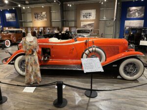 A red 1933 Auburn convertible displayed with a floral vintage dress at the Fountainhead Antique Auto Museum in Fairbanks.