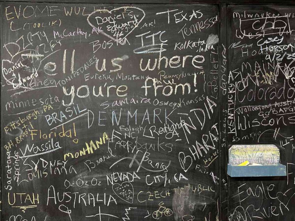 Chalkboard filled with colourful signatures and messages from visitors around the world.