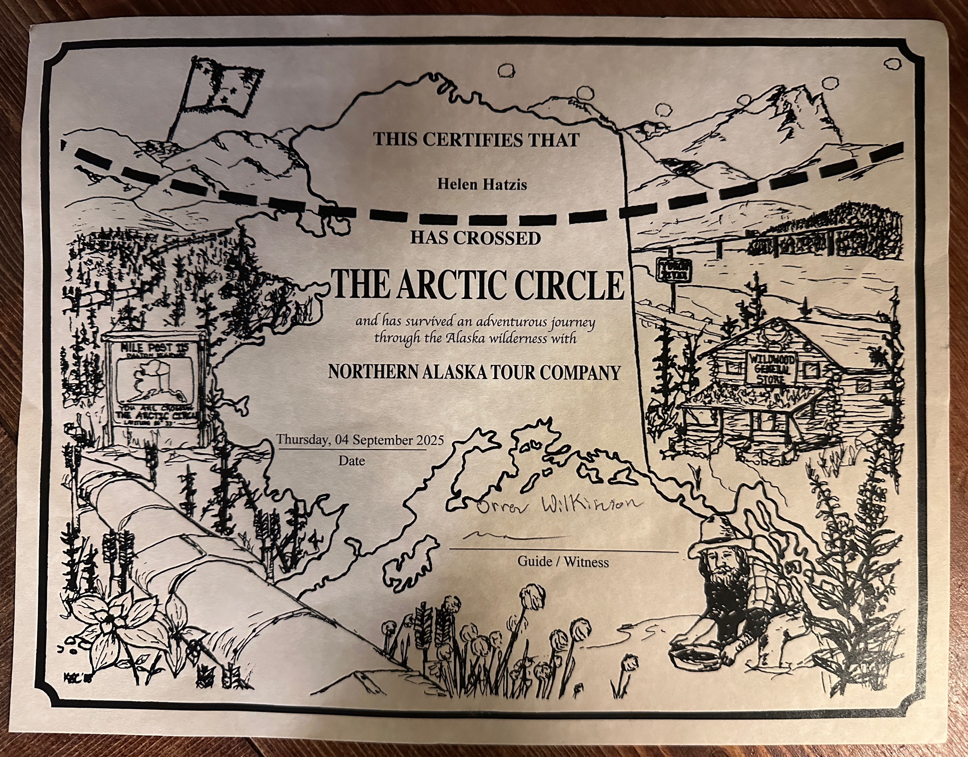 A certificate from the Northern Alaska Tour Company awarded to Helen Hatzis for crossing the Arctic Circle on September 4, 2025, decorated with illustrated Alaskan wilderness scenes.