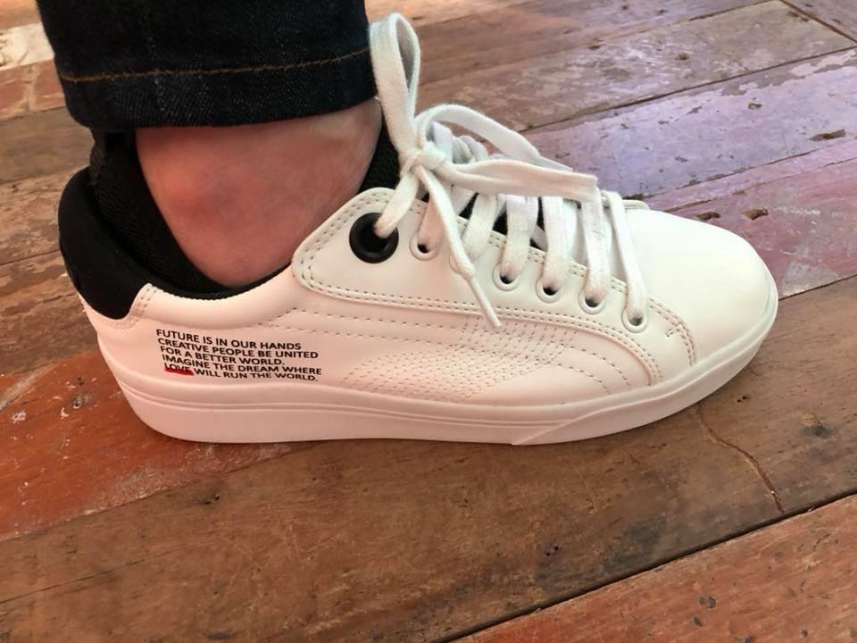 Author’s white sneaker printed with a message about the future being in our hands, symbolising conscious steps across borders. I don’t just talk the talk about conscious travel—I walk the walk, with the reminder literally written on my shoe every time I cross the border.