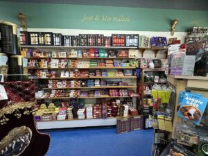 Shelves labelled “Jam & Marmalade” at the British Emporium, filled with boxed biscuits, preserves, crackers and seasonal treats.
