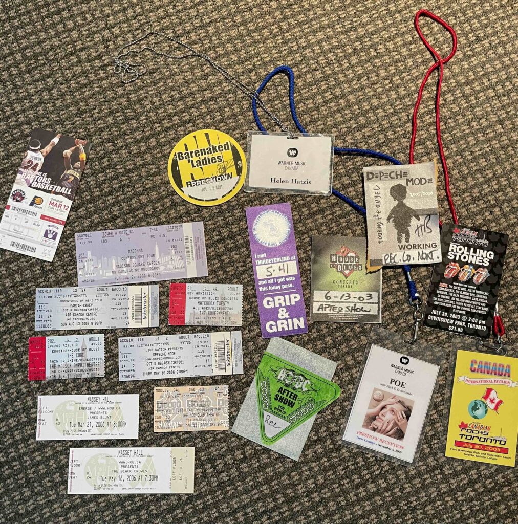 Collection of concert tickets, backstage passes, and lanyards spread on carpet, including a name badge and vintage event memorabilia.