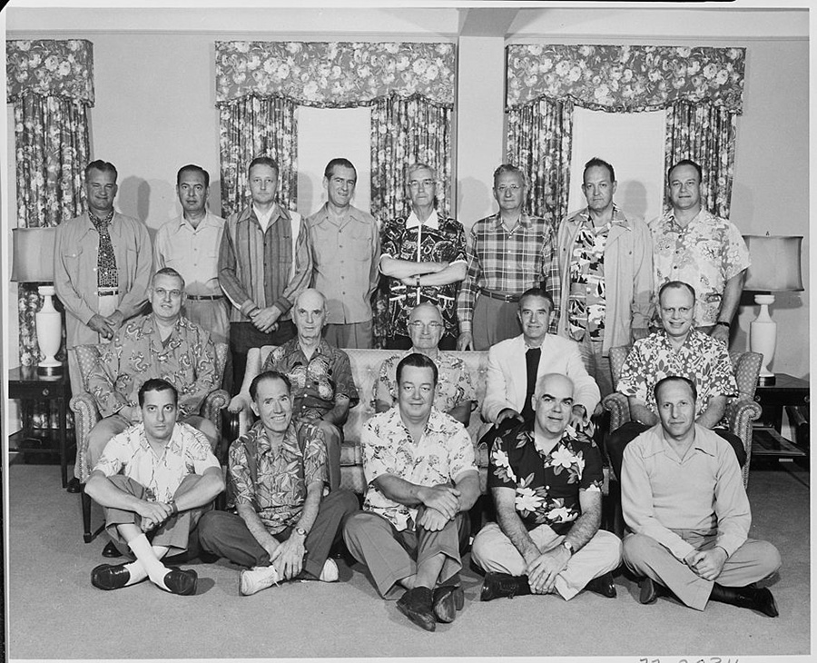 Black-and-white group photo of President Harry S. Truman seated with his vacation party in a living-room setting; several men wear patterned Hawaiian shirts.
