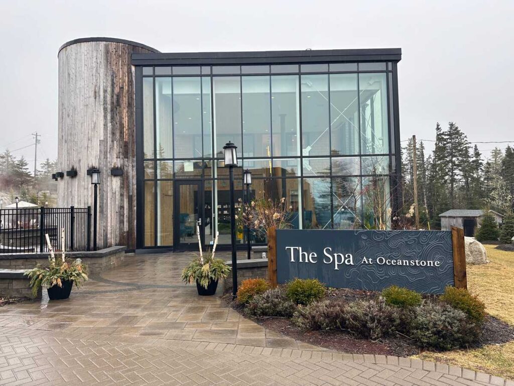 Entrance to The Spa at Oceanstone with modern glass facade and weathered wood exterior in Indian Harbour, Nova Scotia.