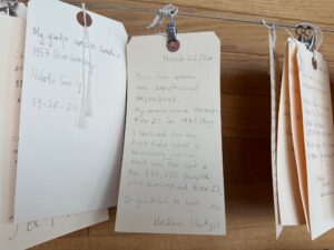 Close-up of handwritten visitor tags hanging on a display wall at Pier 21, including a note describing an emotional visit connected to family immigration history.