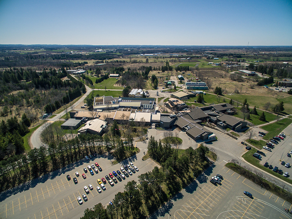 Aerial view of Frost Campus at Fleming College surrounded by farmland and forests near Lindsay Ontario