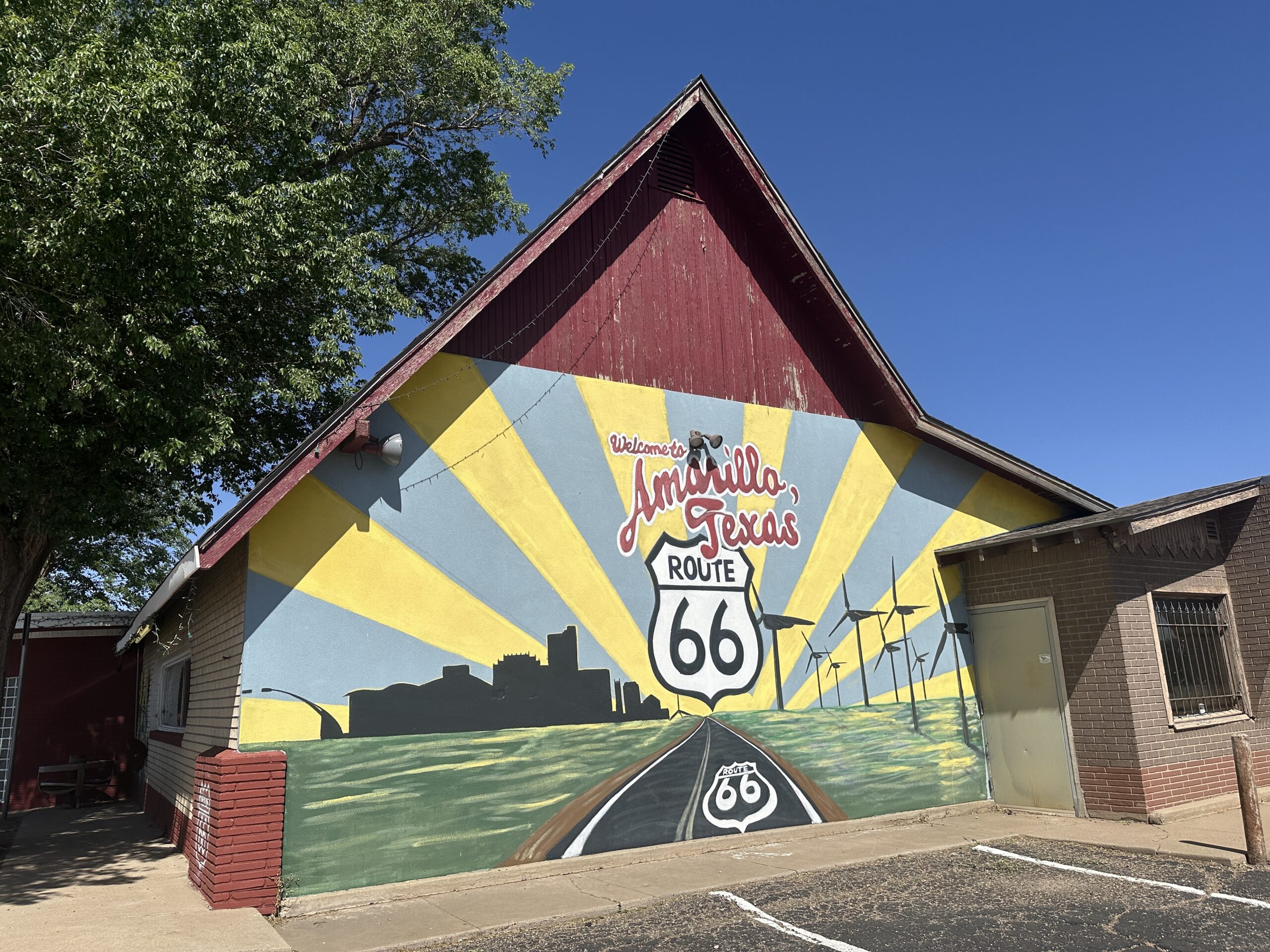 Colourful mural on a building in Amarillo, Texas, showing a Route 66 road, wind turbines, and the words “Welcome to Amarillo, Texas.”