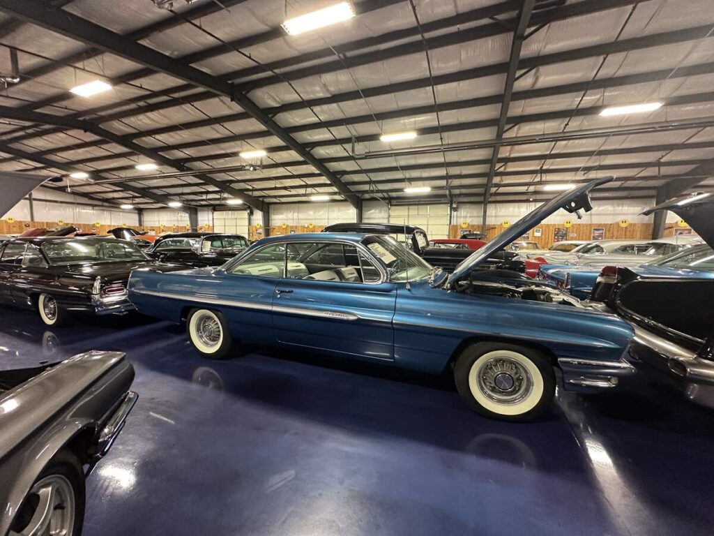Blue vintage Pontiac Catalina displayed among classic cars inside Bill’s Backyard Classics in Amarillo, Texas.