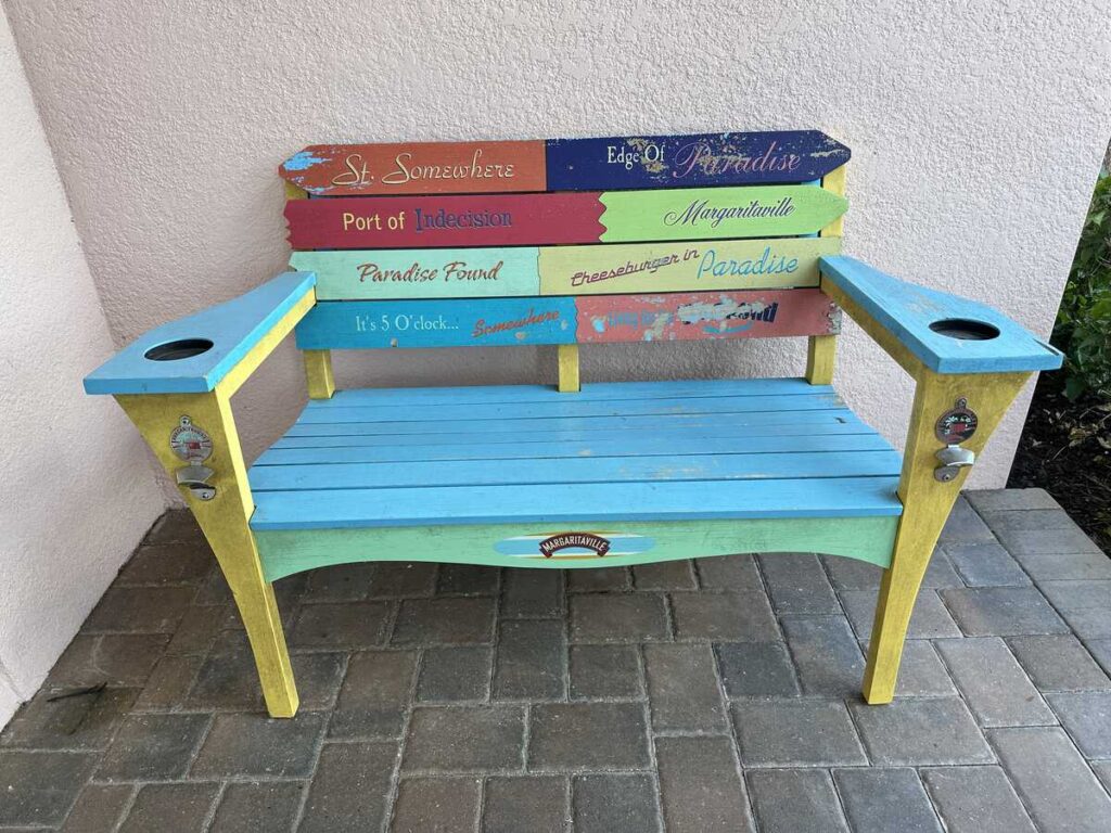 Colourful Margaritaville bench painted with playful paradise-themed phrases and song references.