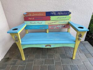 Colourful Margaritaville bench painted with playful paradise-themed phrases and song references.