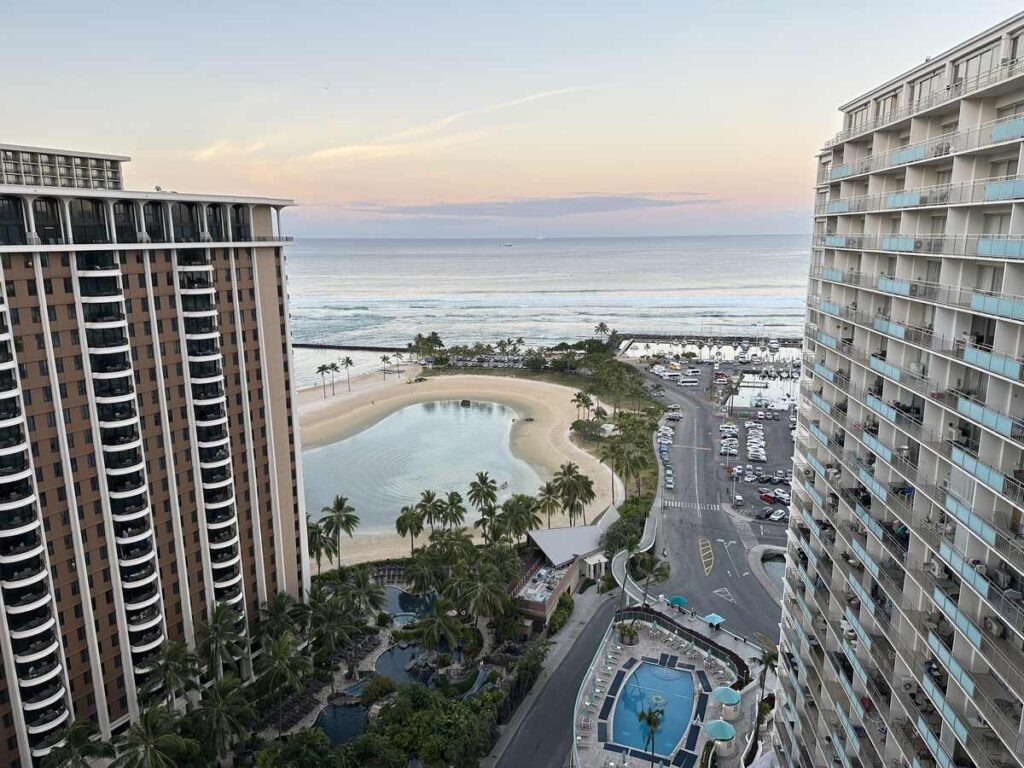 Early morning view of Waikīkī, the Pacific Ocean, and surrounding hotel towers from above.