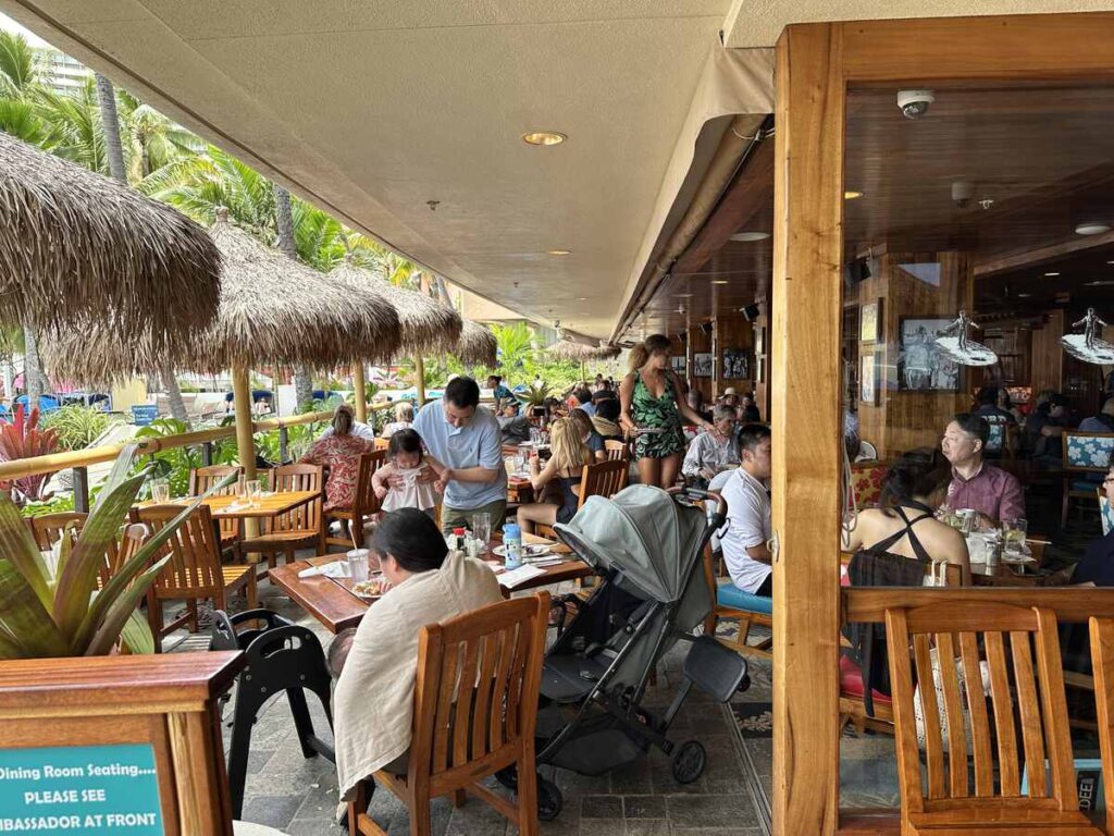 Diners seated inside Duke’s Waikīkī restaurant.