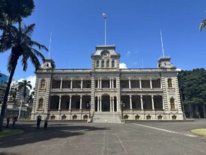 Exterior of ʻIolani Palace in Honolulu under a clear blue sky.