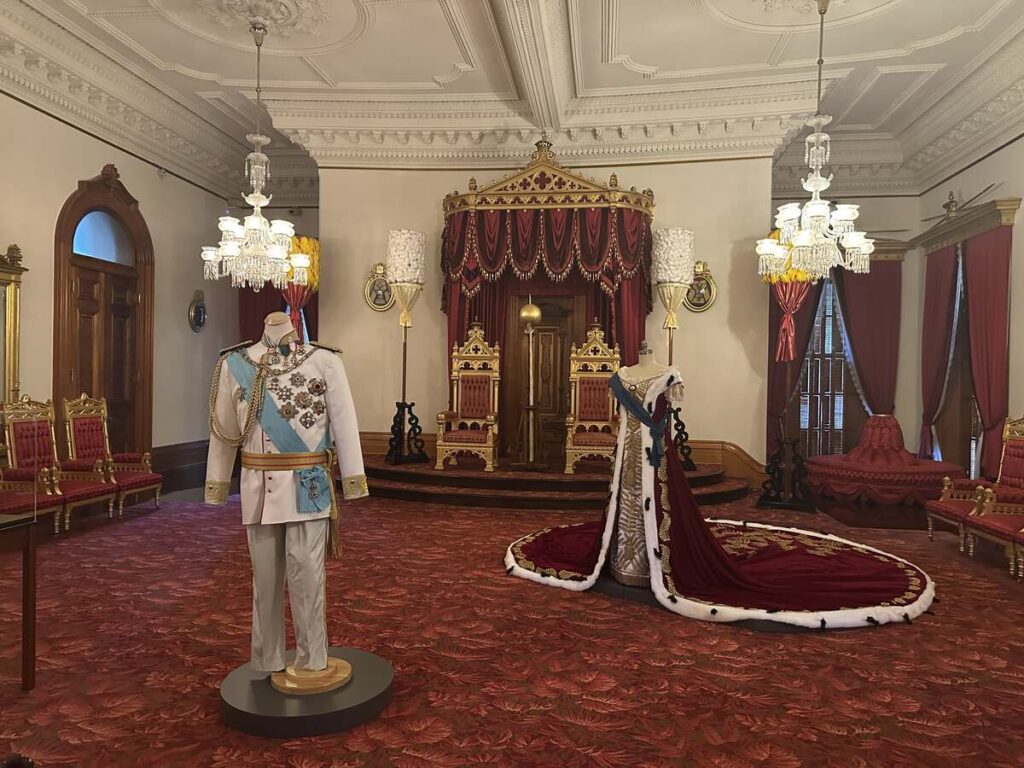 Throne room inside ʻIolani Palace with royal regalia and ceremonial furnishings.
