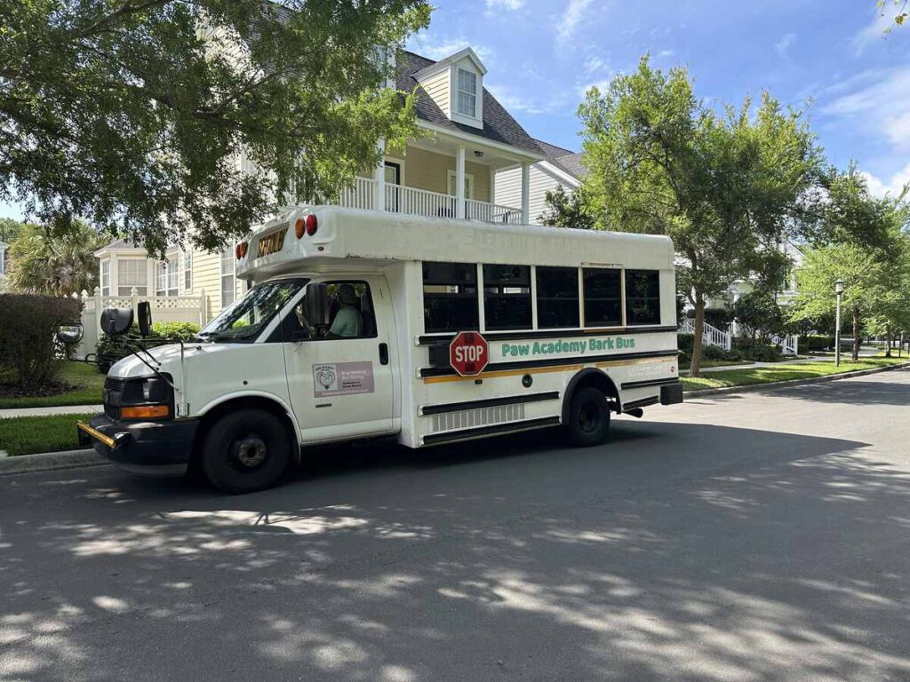 White Paw Academy Bark Bus parked on a shaded residential street in Celebration.