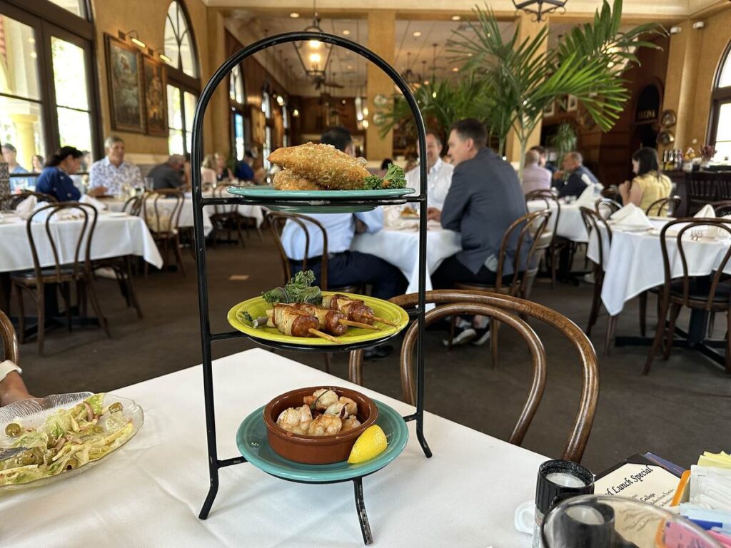 Three-tier tapas stand with empanadas, grilled skewers, and shrimp served inside Columbia Restaurant in Celebration, Florida.