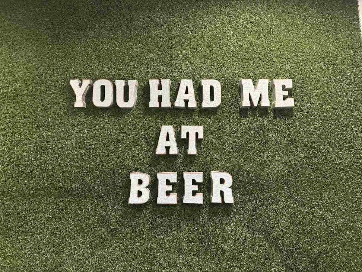 “You Had Me at Beer” sign displayed on a green grass-textured wall at My Beer Spa.