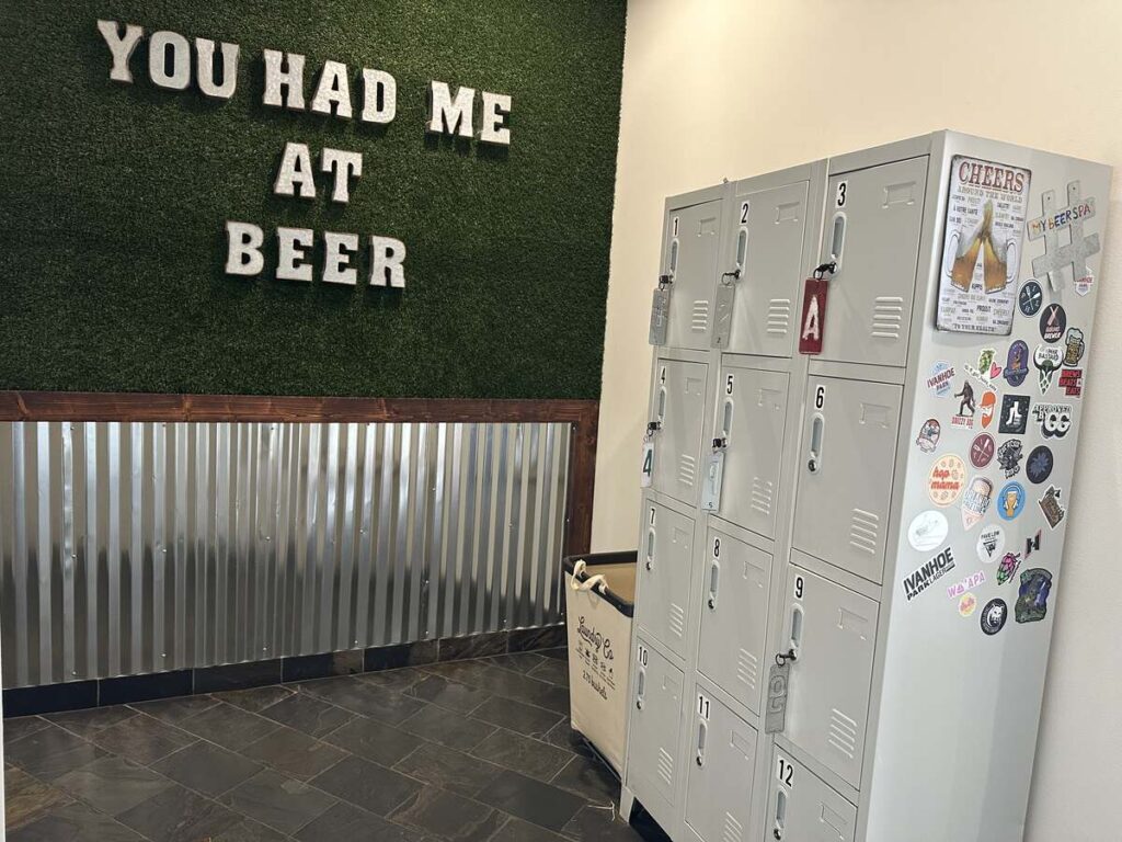 Locker area at My Beer Spa with a “You Had Me at Beer” wall sign and numbered lockers.