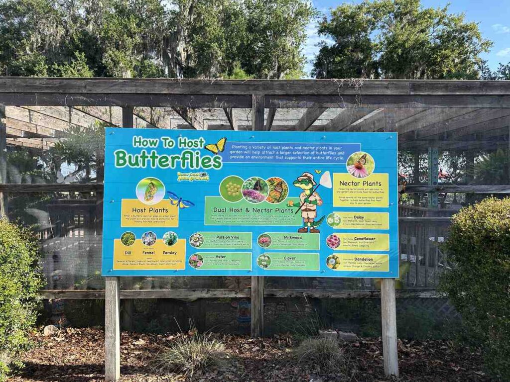 Blue sign at Boggy Creek explaining host plants, nectar plants, and how to support butterflies.