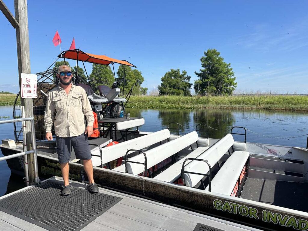 Airboat captain standing beside an airboat at the dock before a ride through the wetlands.