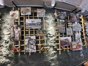 A history wall at Tūtū’s Place by Highway Inn displays photographs, menus, packaging, and stories from the restaurant’s family legacy.