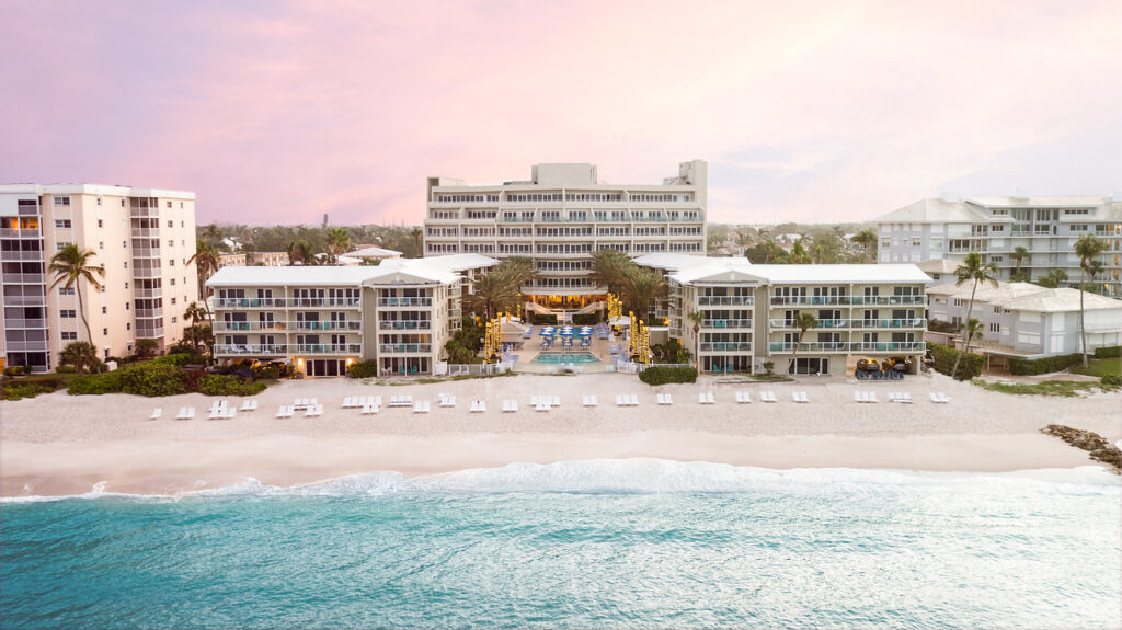Aerial view of Edgewater Beach Hotel on the beach in Naples, Florida, with Gulf waves, white sand, and the hotel buildings at sunset.