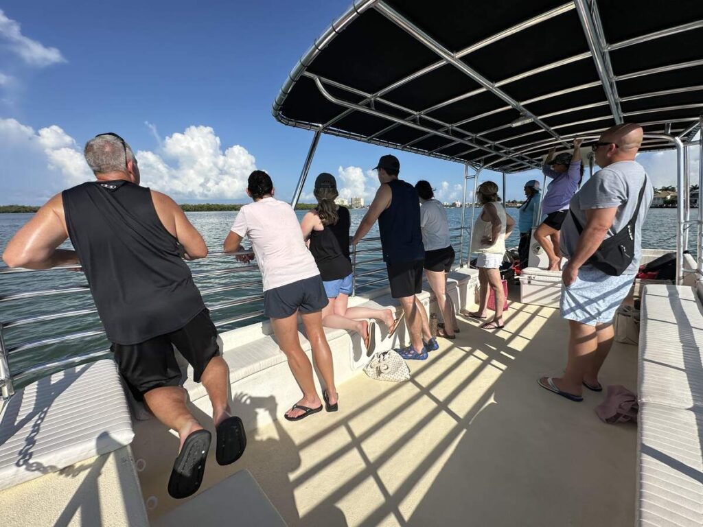 Passengers on a covered boat watch the water during a Marco Island eco tour through the Ten Thousand Islands.