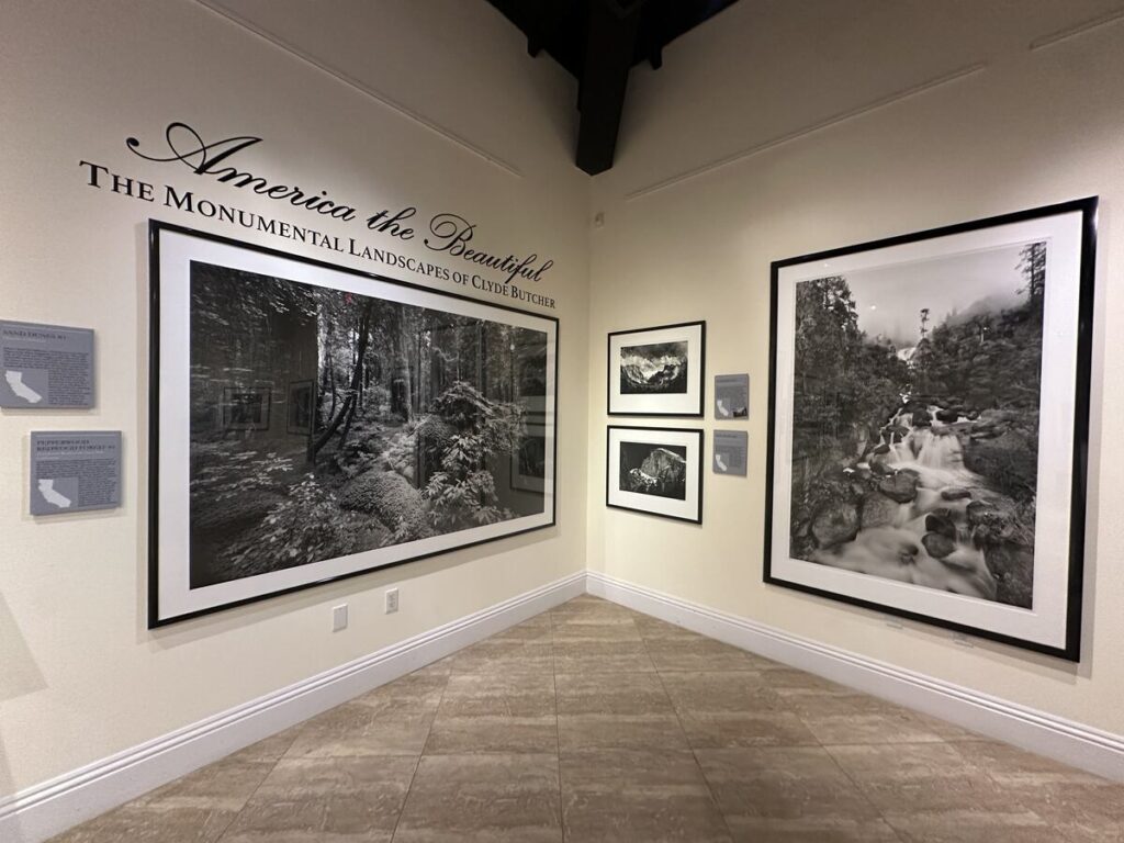 Clyde Butcher exhibition titled America the Beautiful with large black-and-white landscape photographs on gallery walls.