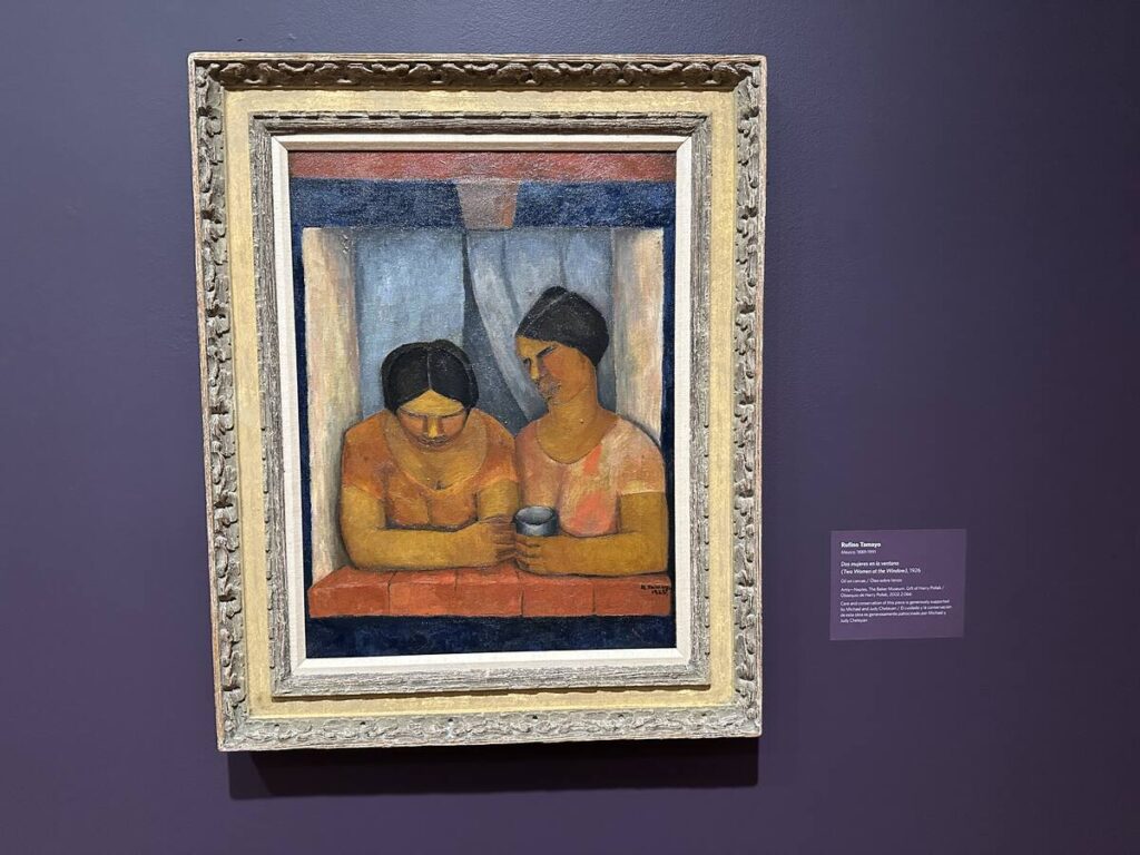 Framed Rufino Tamayo painting of two women at a window, displayed on a purple museum wall.
