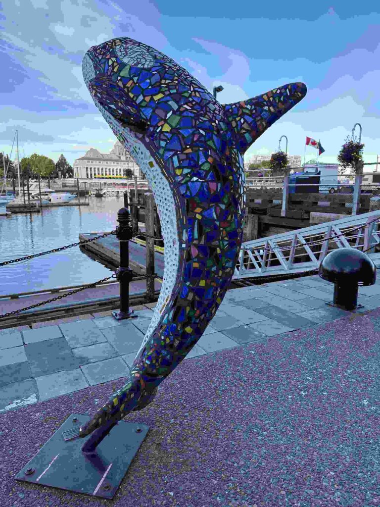 Colourful mosaic orca sculpture beside Victoria’s Inner Harbour and marina.