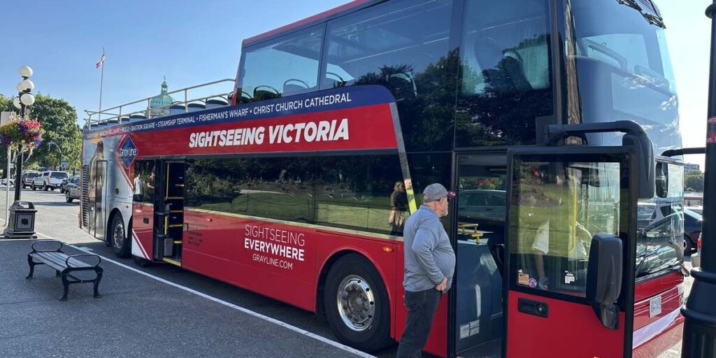 Red hop-on-hop-off Sightseeing Victoria double-decker bus in downtown Victoria.